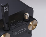 Close-up of a black electronic device with gold accents and 'BROD' branding.